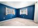 Cozy bedroom with neutral carpet, dark-blue walls, white curtains, and a pair of bright windows with blinds at 690 S Lakemont Ave, Winter Park, FL 32792