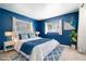 Cozy bedroom with soft blue walls, a large bed, and natural light from the two large windows at 690 S Lakemont Ave, Winter Park, FL 32792