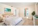 Bright bedroom features a stylish bed with soft pink accents, with an ensuite bathroom, and relaxing tropical decor at 690 S Lakemont Ave, Winter Park, FL 32792