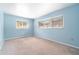 Comfortable bedroom with neutral carpet, light-blue walls, and a pair of bright windows with blinds at 690 S Lakemont Ave, Winter Park, FL 32792