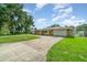 Ranch style home featuring a stone facade, two-car garage, lush lawn and lengthy drive at 690 S Lakemont Ave, Winter Park, FL 32792