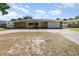 Charming single-story home featuring a stone facade, solar panels, a two-car garage and a curved driveway at 690 S Lakemont Ave, Winter Park, FL 32792