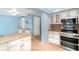 The eat-in kitchen features granite countertops, stainless steel appliances, and neutral tile flooring at 690 S Lakemont Ave, Winter Park, FL 32792