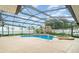 A refreshing pool and spa surrounded by an enclosed screen, a paved deck, and manicured landscaping at 690 S Lakemont Ave, Winter Park, FL 32792