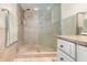 Beautifully tiled shower with glass door, complemented by granite countertops, towel racks and vanity drawers at 690 S Lakemont Ave, Winter Park, FL 32792