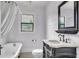 Bathroom with clawfoot tub, decorative vanity, and a classic black framed mirror at 712 Baffie Ave, Winter Park, FL 32789