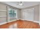 Neutral bedroom featuring hardwood floors, a ceiling fan, a window, and a double door closet at 712 Baffie Ave, Winter Park, FL 32789
