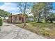 Landscaped front yard and charming single-story home with a red brick chimney and ample sunlight at 712 Baffie Ave, Winter Park, FL 32789