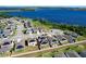 Lovely community aerial view showcases houses with solar panels surrounded by green spaces and a lake at 744 Simone Ct, Haines City, FL 33844