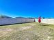 Backyard with grass, white fence, and shade umbrella at 744 Simone Ct, Haines City, FL 33844