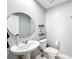 Powder room with a pedestal sink, round mirror, and modern fixtures at 744 Simone Ct, Haines City, FL 33844