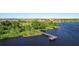 Scenic view of a wooden dock extending into the calm lake waters, surrounded by green vegetation at 744 Simone Ct, Haines City, FL 33844