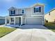 Charming two-story home featuring a landscaped front yard, attached garage, and welcoming covered front porch at 744 Simone Ct, Haines City, FL 33844