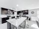 Modern kitchen featuring an island with seating, stainless steel appliances, and dark wood cabinetry at 744 Simone Ct, Haines City, FL 33844