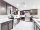 Stylish kitchen with stainless steel appliances, dark cabinets, and ample counter space at 744 Simone Ct, Haines City, FL 33844