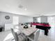 Open-concept living area with dining table, pool table, and access to a large gray couch at 744 Simone Ct, Haines City, FL 33844
