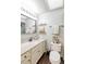 Well-lit bathroom with a vanity, framed mirror, toilet and decorative shelves at 7714 Lady Frances Way, Orlando, FL 32807