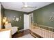 Bedroom with a crib, cozy chair, and dark green walls at 7714 Lady Frances Way, Orlando, FL 32807