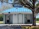 Exterior view of a convenient public restroom facility, featuring a blue metal roof, and labeled doors at 7714 Lady Frances Way, Orlando, FL 32807