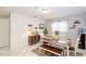 Bright dining room with wooden table, bench seating, and white tile floor with decor at 7714 Lady Frances Way, Orlando, FL 32807