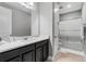 Bathroom featuring a sink, white countertop, cabinets, shower with glass doors, and modern fixtures at 8384 Ludington Cir, Orlando, FL 32836