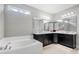 Bright bathroom with a tub, stylish cabinets, and an expansive mirror that amplifies the natural light at 8384 Ludington Cir, Orlando, FL 32836