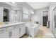 Bathroom features a double sink, large soaking tub, and walk in shower and neutral colors at 8384 Ludington Cir, Orlando, FL 32836