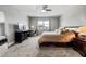 This bedroom features carpeted floors, a ceiling fan, and a window that brings in plenty of natural light at 8384 Ludington Cir, Orlando, FL 32836
