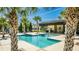Community pool with turquoise blue water surrounded by palm trees and lounge chairs at 8384 Ludington Cir, Orlando, FL 32836