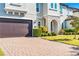 Close up of exterior elevation, showing stone archway, large garage door, and landscaped front yard at 8384 Ludington Cir, Orlando, FL 32836