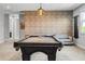 Spacious game room boasting a pool table, exposed brick wall, and comfortable seating area at 8384 Ludington Cir, Orlando, FL 32836