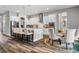 Modern eat-in kitchen boasts a large island, stainless steel appliances, and hardwood floors adjacent to dining area at 8384 Ludington Cir, Orlando, FL 32836
