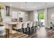 Open concept kitchen with stainless steel hood, white cabinets, quartz countertops, and eat in dining area at 8384 Ludington Cir, Orlando, FL 32836