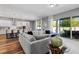 Bright living room featuring hardwood floors, a sliding glass door to the pool, and adjoins the kitchen at 8384 Ludington Cir, Orlando, FL 32836