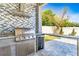 Outdoor kitchen with stainless steel grill, counter space, beverage cooler, and bar seating at 8384 Ludington Cir, Orlando, FL 32836