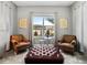 Sitting area with matching plaid chairs, dark brown tufted ottoman and a sun-filled window at 8384 Ludington Cir, Orlando, FL 32836
