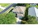 Aerial view of a well-maintained home with a large roof, two car garage, green lawn and mature trees at 8500 Palm Harbour Dr, Kissimmee, FL 34747