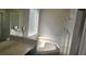 Bright bathroom featuring a large soaking tub, marble countertops and framed mirror at 8500 Palm Harbour Dr, Kissimmee, FL 34747