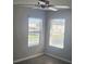 Bedroom featuring gray walls, ceiling fan, and windows providing views of outside at 8500 Palm Harbour Dr, Kissimmee, FL 34747