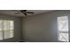 A cozy bedroom with two windows bringing in natural light and ceiling fan at 8500 Palm Harbour Dr, Kissimmee, FL 34747
