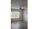 This bedroom has gray walls and gray wood flooring with a ceiling fan and window at 8500 Palm Harbour Dr, Kissimmee, FL 34747