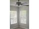 This bedroom has gray walls and gray wood flooring with two windows at 8500 Palm Harbour Dr, Kissimmee, FL 34747