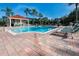 Large community swimming pool with lounge chairs, a poolside cabana and lush landscaping at 8500 Palm Harbour Dr, Kissimmee, FL 34747