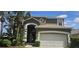 Charming two-story home featuring an attached two car garage and well maintained landscaping with palm trees at 8500 Palm Harbour Dr, Kissimmee, FL 34747