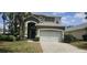 Charming two-story home featuring an attached two car garage and well maintained landscaping with palm trees at 8500 Palm Harbour Dr, Kissimmee, FL 34747