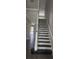 An indoor staircase with tile and wood steps and white banister in a neutral colored interior at 8500 Palm Harbour Dr, Kissimmee, FL 34747
