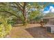 Serene backyard featuring lush greenery, shaded by mature trees, and partial fencing at 1002 Kelsey Ave, Oviedo, FL 32765