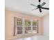 Bright bedroom featuring neutral colors, a ceiling fan, and large windows offering views of the enclosed lanai at 1002 Kelsey Ave, Oviedo, FL 32765