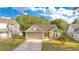 Well-maintained home showcasing a manicured lawn, a long driveway, and an attached two-car garage at 1002 Kelsey Ave, Oviedo, FL 32765