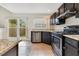 Galley kitchen featuring granite counters, stainless steel appliances, and dark cabinetry at 1002 Kelsey Ave, Oviedo, FL 32765